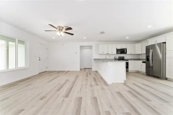 a view of kitchen with stainless steel appliances refrigerator stove microwave and cabinets