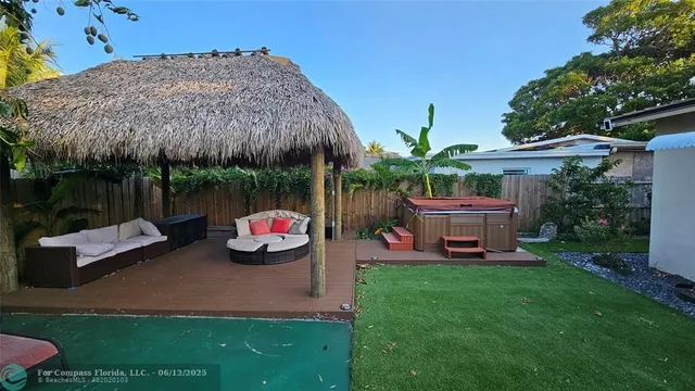 a backyard of a house with table and chairs potted plants and a fire pit