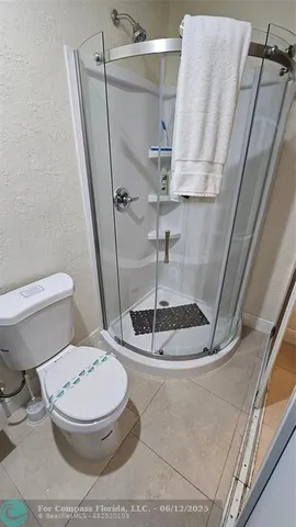 a white toilet sitting next to a shower