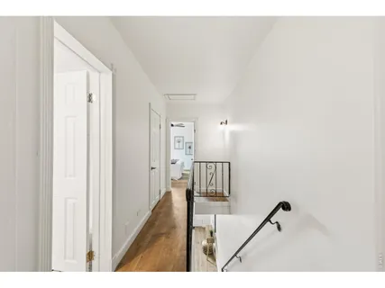 a view of a hallway with a white walls and stairs