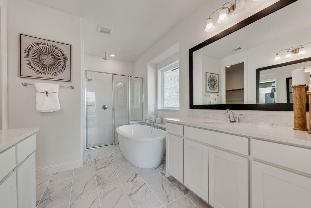 12711 Pne Rdg Trail Wylie, TX 75098 - Photo 15 of 30 a spacious bathroom with a double vanity sink a mirror and a bathtub
