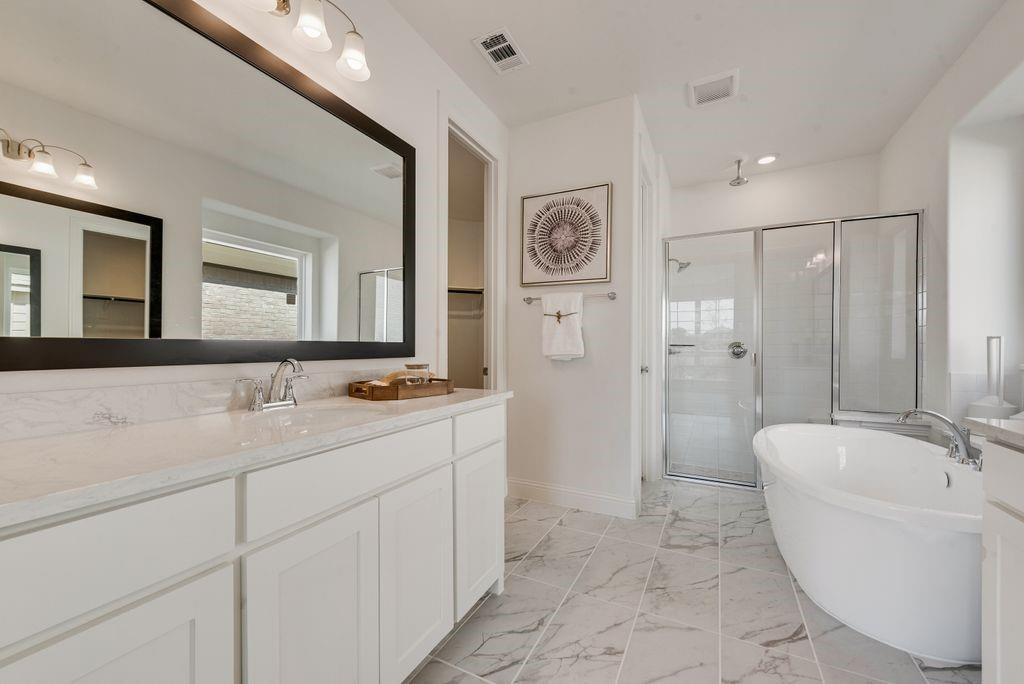 12711 Pne Rdg Trail Wylie, TX 75098 - Photo 16 of 30 a bathroom with a bathtub sink mirror and shower
