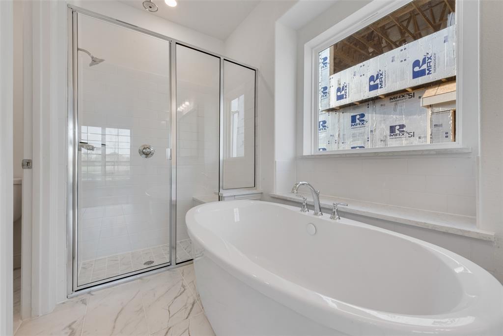 12711 Pne Rdg Trail Wylie, TX 75098 - Photo 17 of 30 a bathroom with a bathtub and a shower