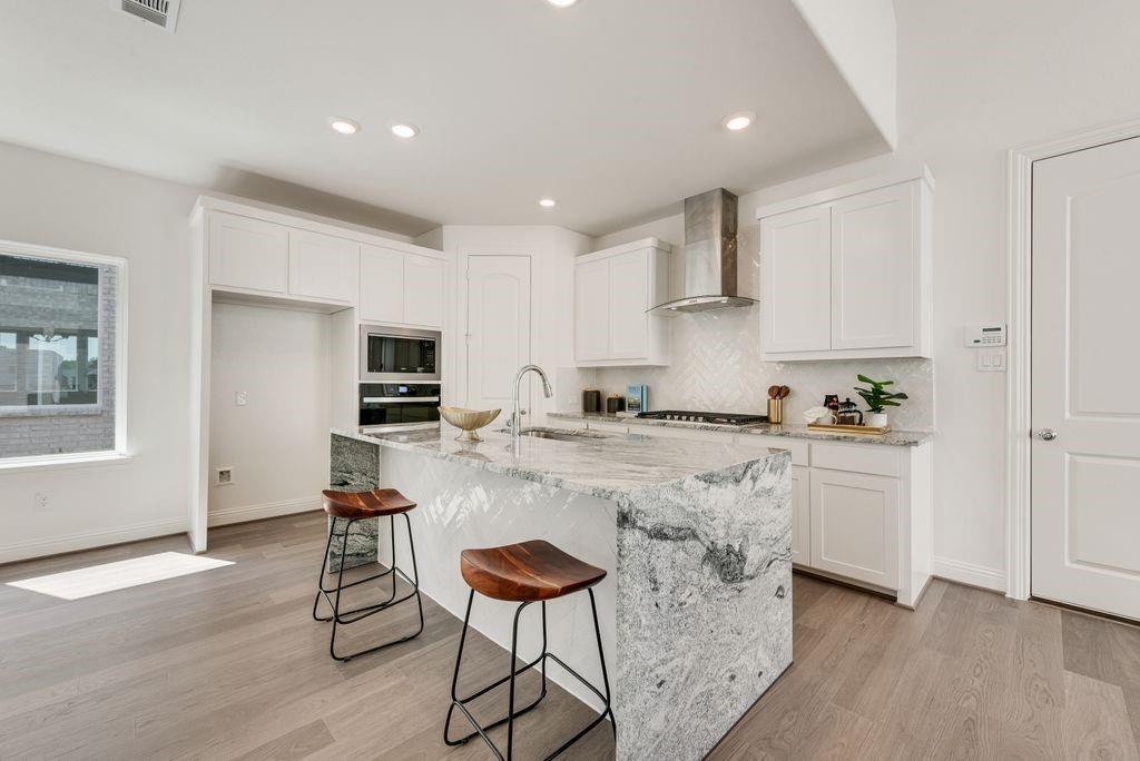 12711 Pne Rdg Trail Wylie, TX 75098 - Photo 7 of 30 a kitchen with stainless steel appliances granite countertop a stove a sink and a refrigerator