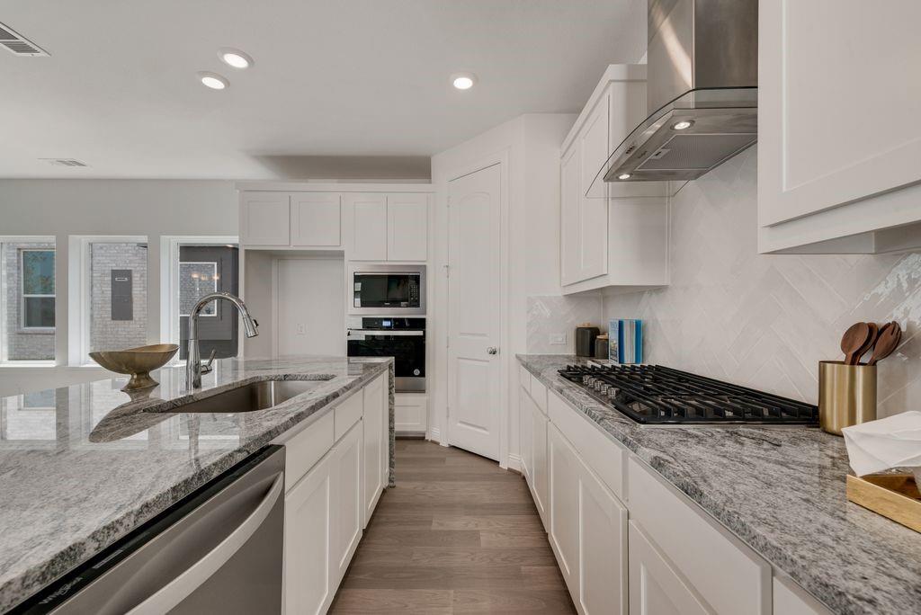 12711 Pne Rdg Trail Wylie, TX 75098 - Photo 9 of 30 a kitchen with stainless steel appliances granite countertop a sink stove and cabinets