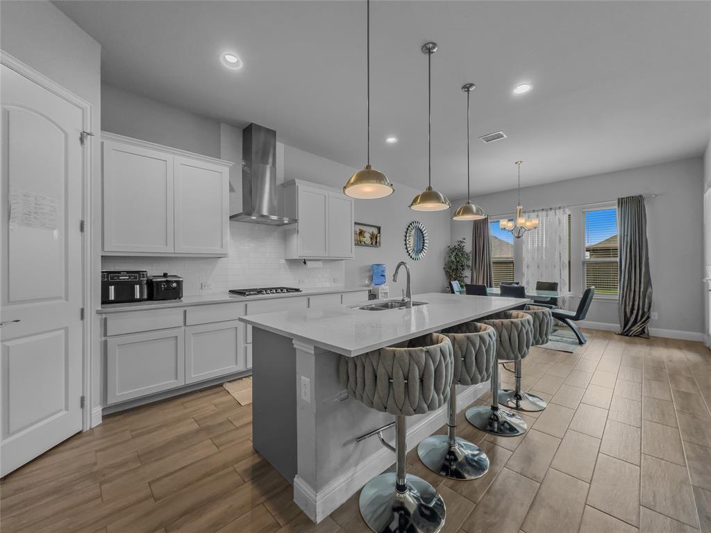 116 Chaco Drive Forney, TX 75126 - Photo 8 of 27 a kitchen with stainless steel appliances kitchen island granite countertop a sink a stove a dining table and chairs
