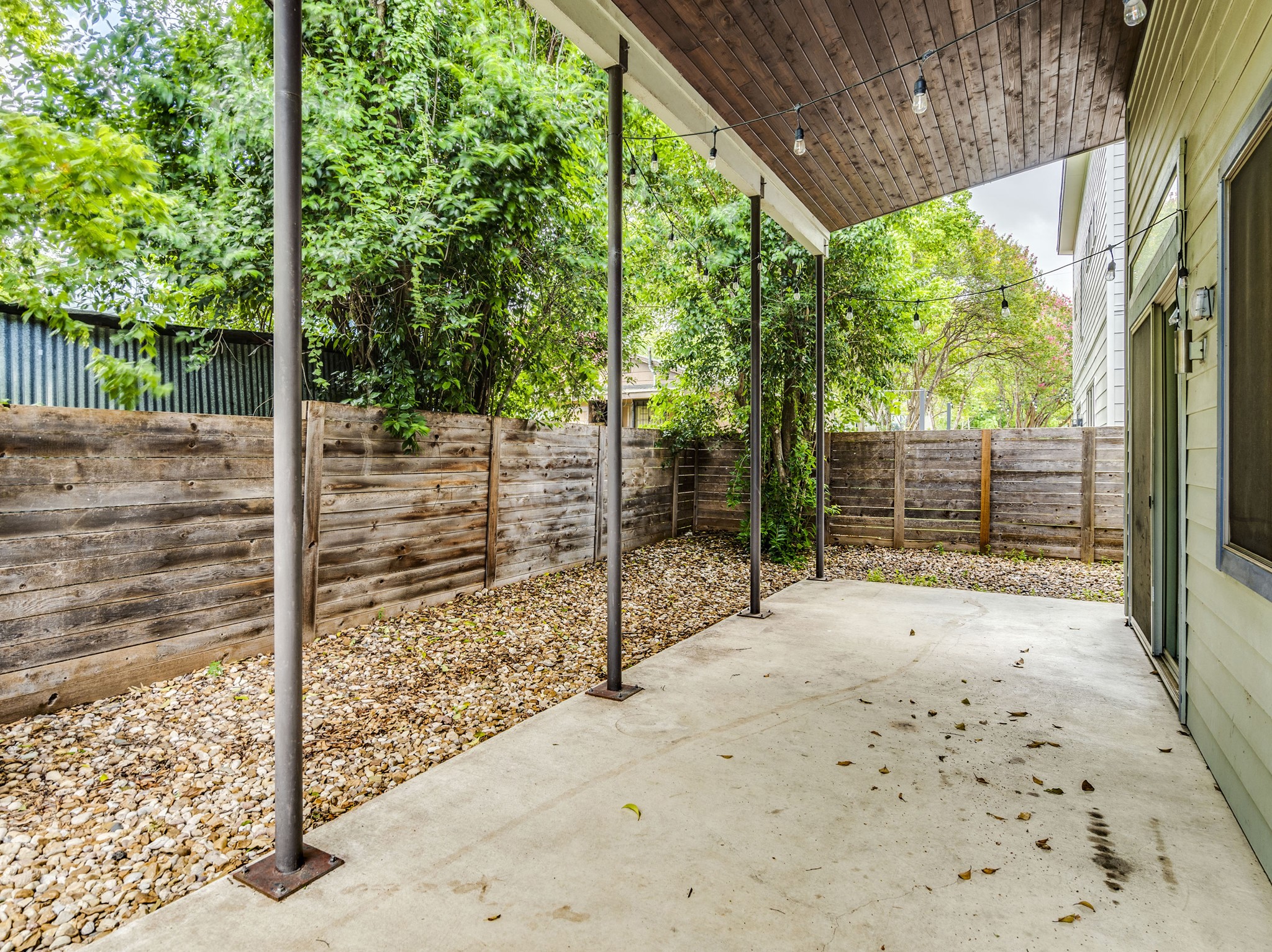 1404 Singleton Avenue, Unit B Austin, TX 78702 - Photo 19 of 21 An inviting covered patio offers a private outdoor retreat with string lighting and a stone-lined garden.