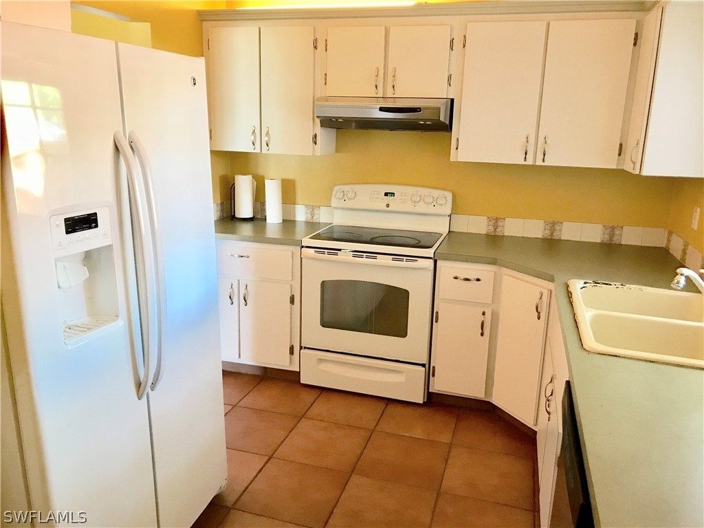 1606 Grove Avenue Fort Myers, FL 33901 - Photo 3 of 7 a kitchen with a white stove refrigerator and cabinets