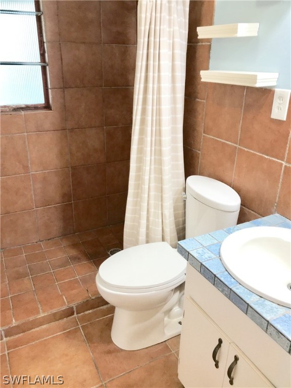 1606 Grove Avenue Fort Myers, FL 33901 - Photo 6 of 7 a white toilet sitting next to a bathroom sink