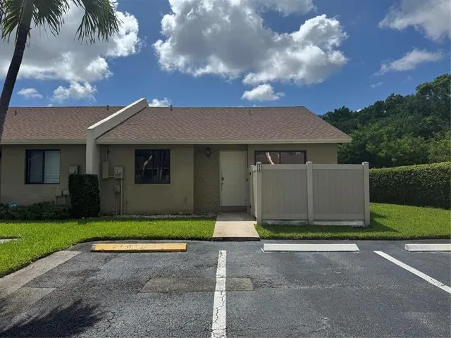 a front view of a house with a garden and yard