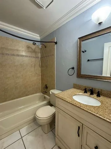 a bathroom with a granite countertop sink a toilet a mirror and shower