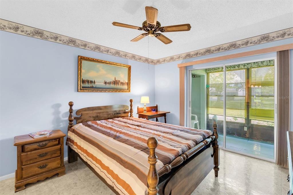 11204 Pembridge Court, Unit 4 Port Richey, FL 34668 - Photo 13 of 58 a bedroom with a bed and a chandelier