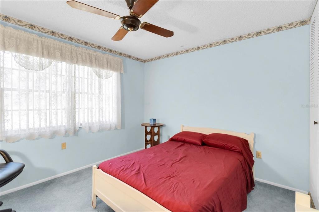 11204 Pembridge Court, Unit 4 Port Richey, FL 34668 - Photo 18 of 58 a bed sitting in a bedroom next to a window