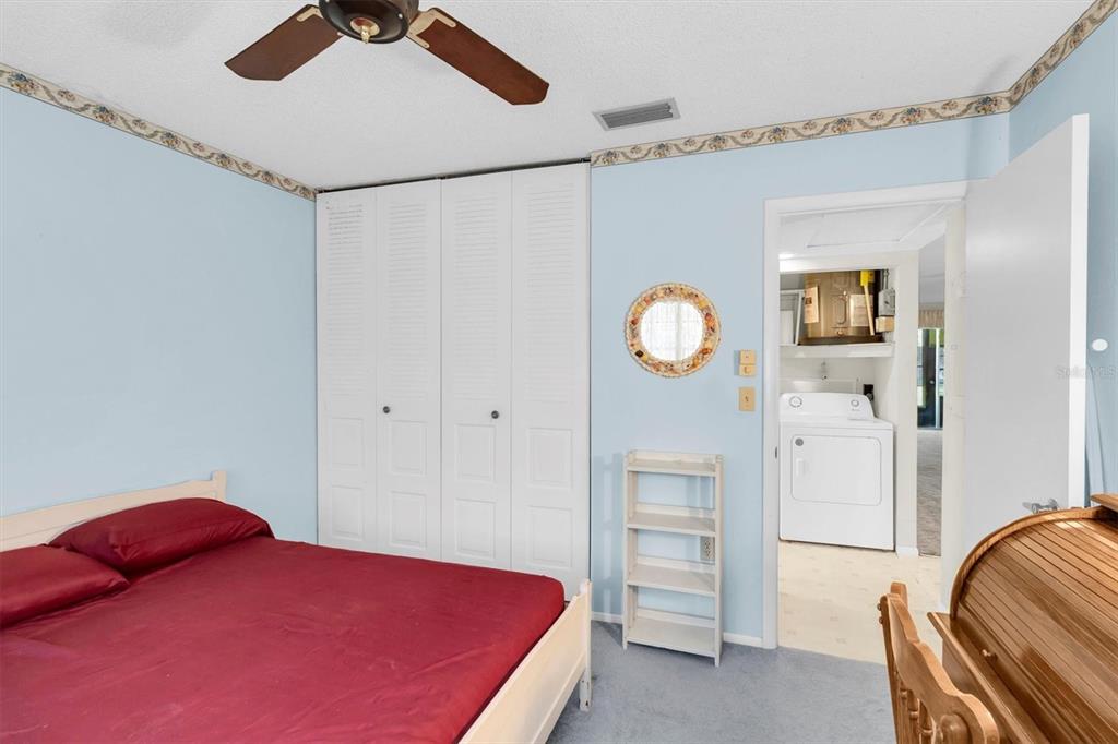 11204 Pembridge Court, Unit 4 Port Richey, FL 34668 - Photo 19 of 58 a bedroom with a bed and a chandelier