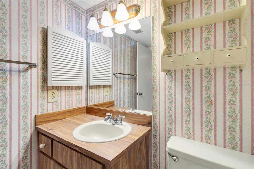 11204 Pembridge Court, Unit 4 Port Richey, FL 34668 - Photo 20 of 58 a bathroom with a sink a mirror and a toilet
