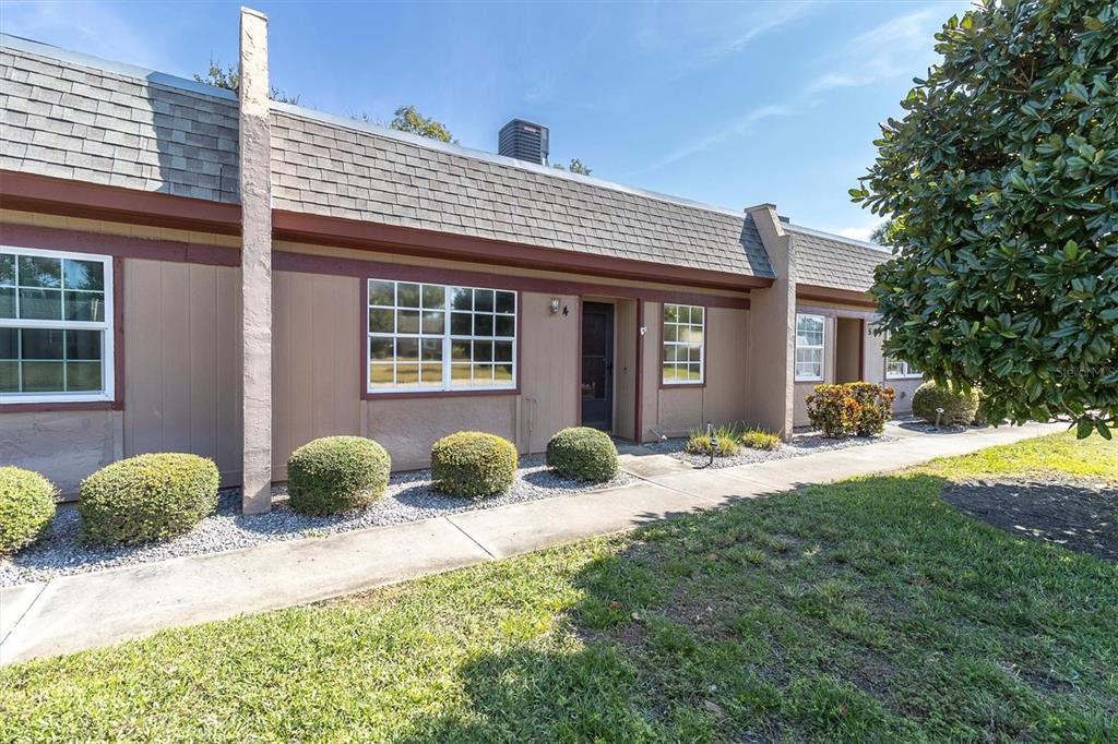 11204 Pembridge Court, Unit 4 Port Richey, FL 34668 - Photo 30 of 58 a front view of a house with a yard and garage