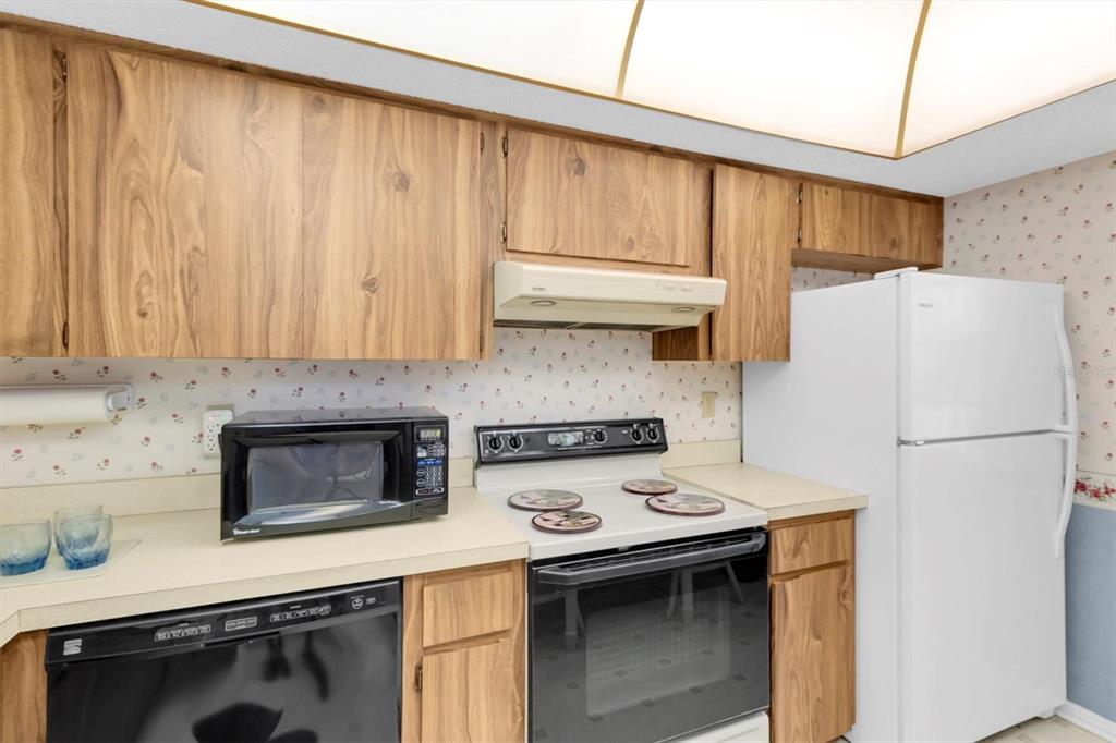 11204 Pembridge Court, Unit 4 Port Richey, FL 34668 - Photo 9 of 58 a kitchen with stainless steel appliances a stove a refrigerator and a sink