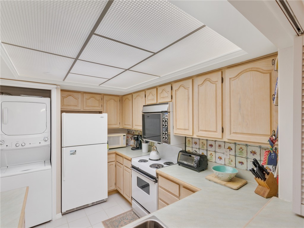 1880 Bay Road, Unit I319 Vero Beach, FL 32963 - Photo 13 of 36 a kitchen with refrigerator a stove a sink dishwasher and white cabinets with wooden floor