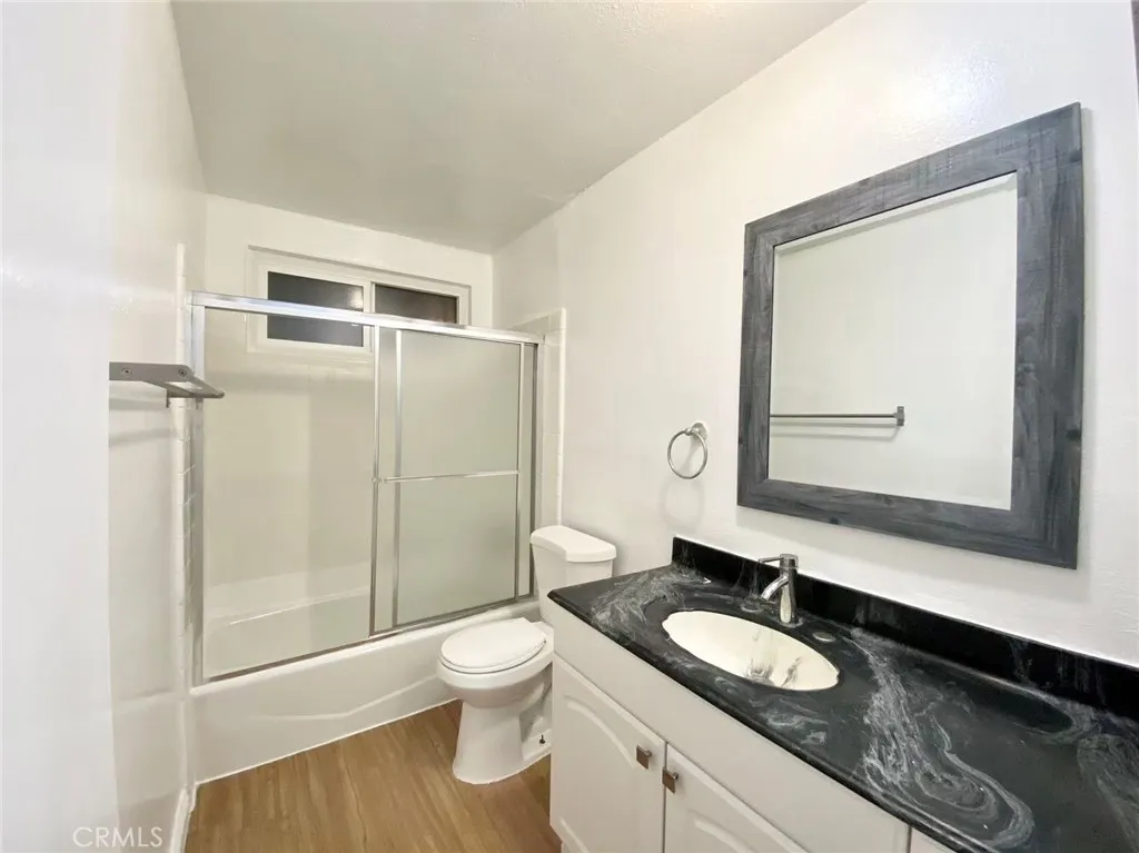 620 East 6th Street Azusa, CA 91702 - Photo 14 of 37 a bathroom with a granite countertop sink toilet mirror vanity and shower