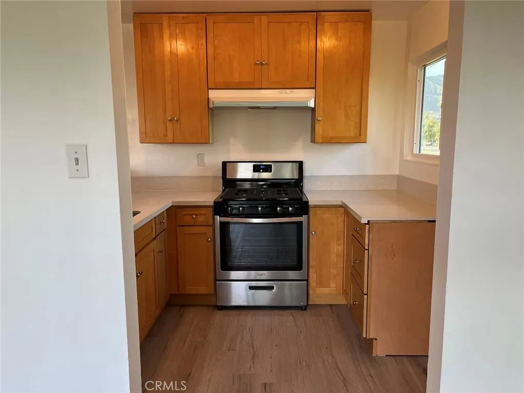 620 East 6th Street Azusa, CA 91702 - Photo 17 of 37 a kitchen with granite countertop white cabinets and black appliances