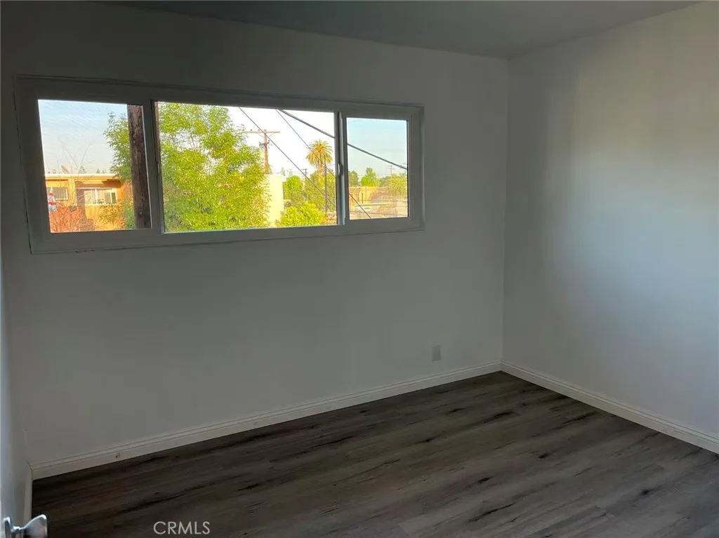 620 East 6th Street Azusa, CA 91702 - Photo 8 of 37 a view of an empty room with wooden floor and a window