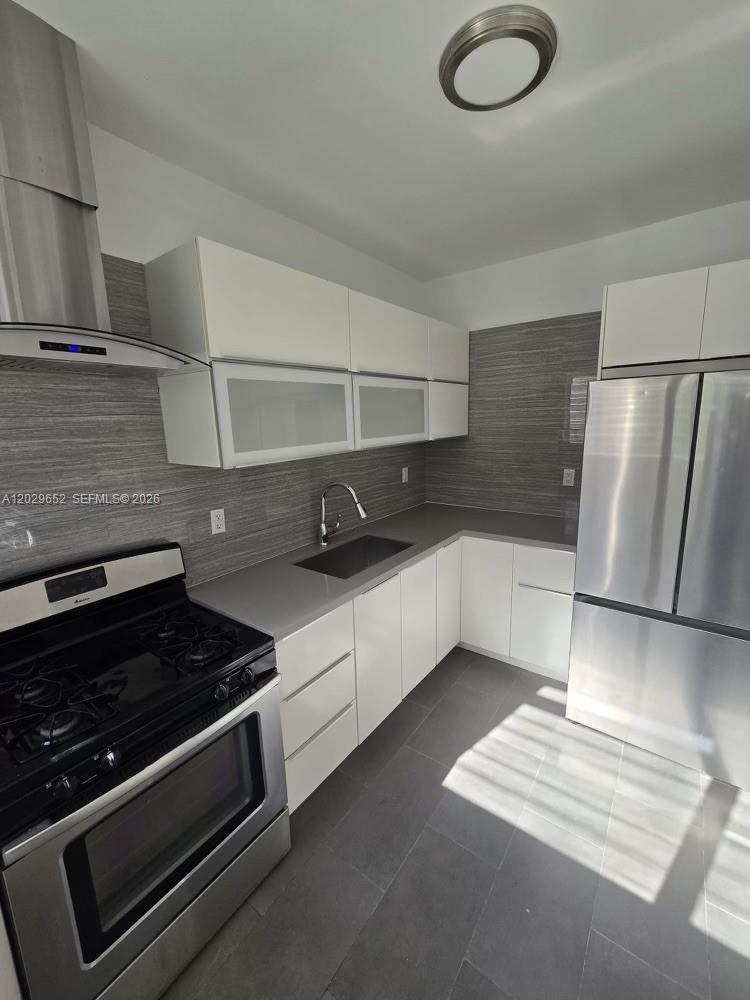 855 80th Street, Unit 4 Miami Beach, FL 33141 - Photo 11 of 16 a kitchen with stainless steel appliances a sink stove and refrigerator