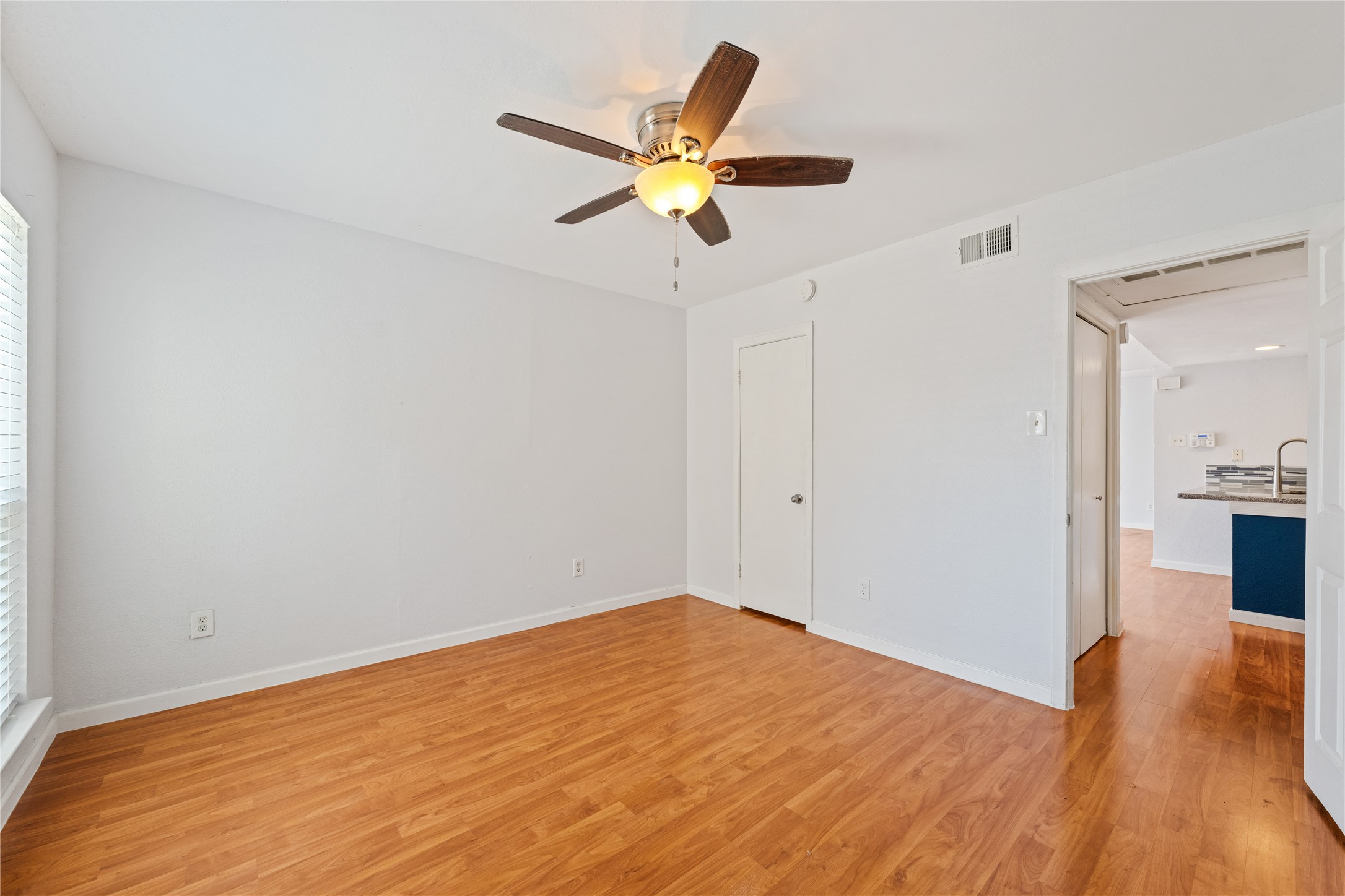 2124 Burton Drive, Unit 159 Austin, TX 78741 - Photo 14 of 23 A versatile space features rich wood flooring, a window providing natural light, and a functional ceiling fan.