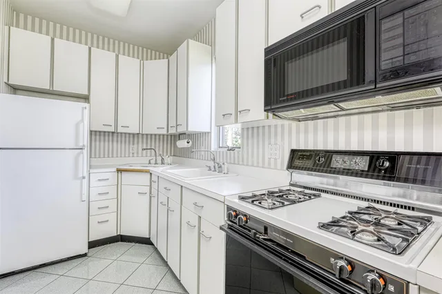 a kitchen with appliances a sink and cabinets