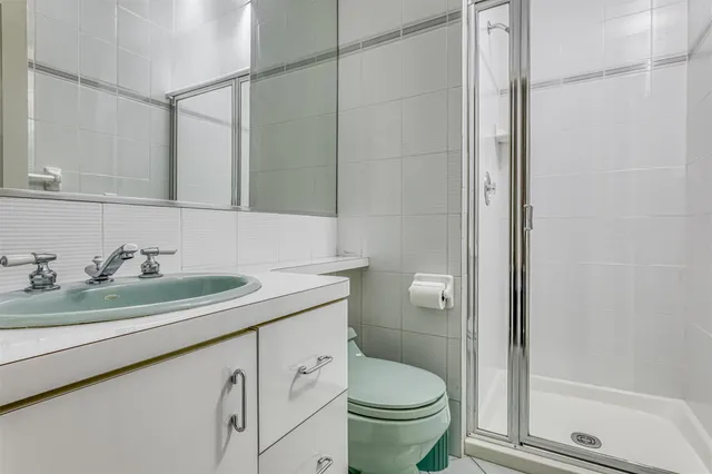 a bathroom with a granite countertop sink toilet and shower