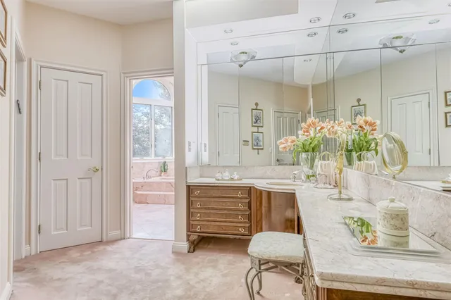 a bathroom with a granite countertop sink a mirror and a bathtub