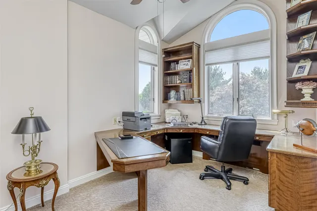 a view of a workspace with furniture and a window
