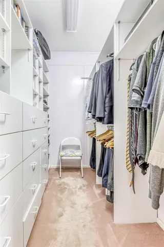 a view of walk in closet with clothes and shoes