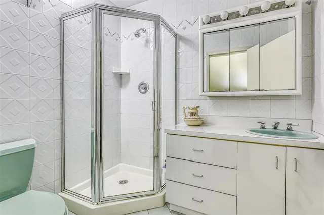 a bathroom with a granite countertop sink toilet and shower