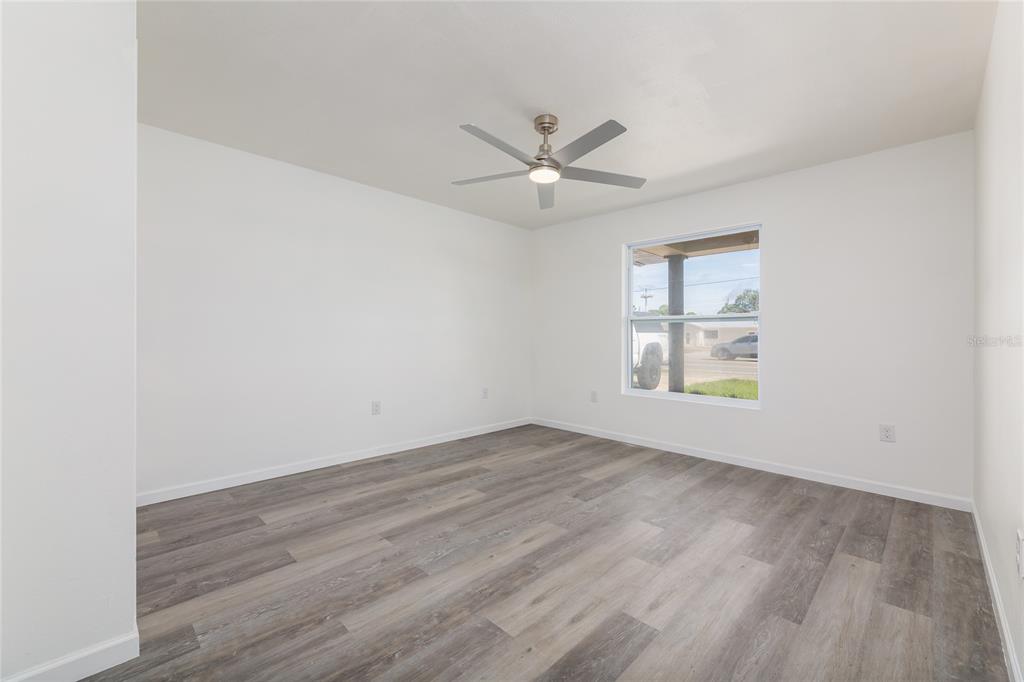 4975 Fay Boulevard Cocoa, FL 32927 - Photo 12 of 35 an empty room with wooden floor fan and windows