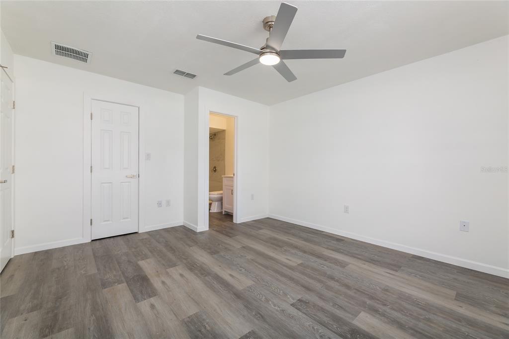 4975 Fay Boulevard Cocoa, FL 32927 - Photo 13 of 35 an empty room with wooden floor and ceiling fan