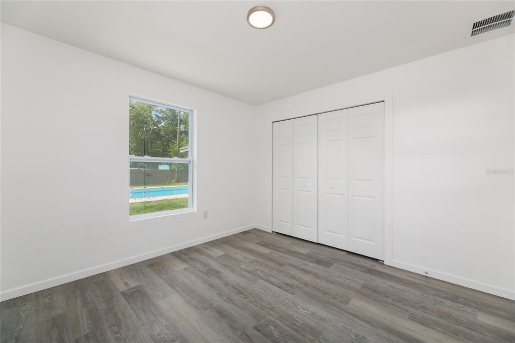 4975 Fay Boulevard Cocoa, FL 32927 - Photo 19 of 35 a view of an empty room with wooden floor and a window