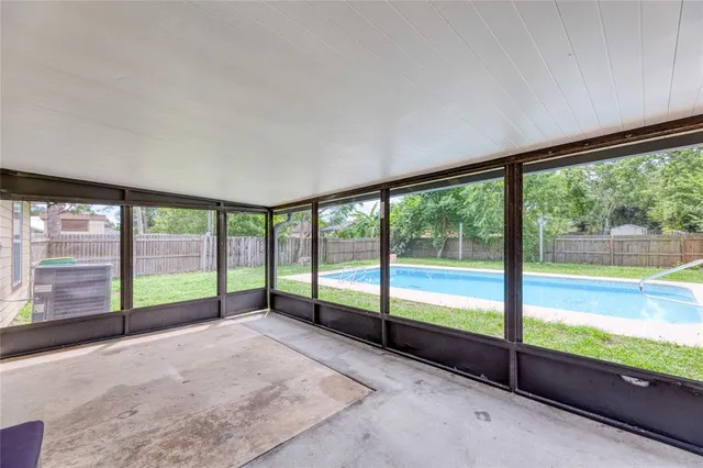 a view of an empty room with wooden floor and a balcony