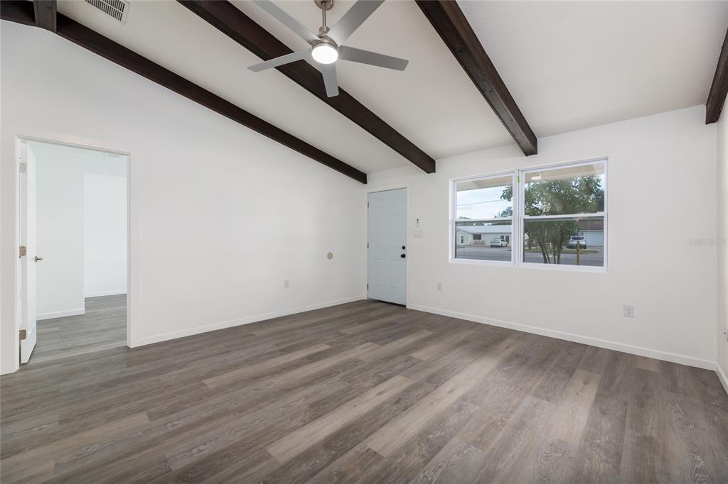 4975 Fay Boulevard Cocoa, FL 32927 - Photo 4 of 35 a view of an empty room with wooden floor and a window