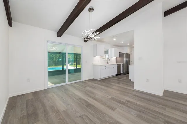 a view of an empty room with a kitchen