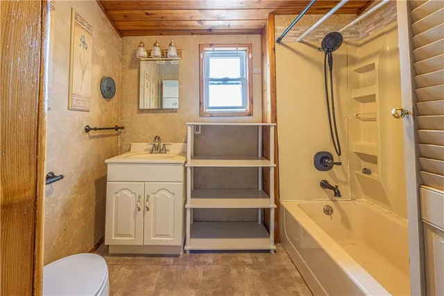 a bathroom with a tub sink and mirror