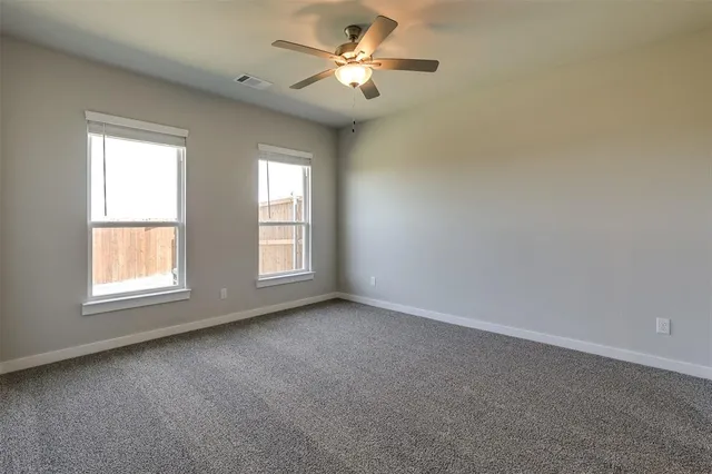 an empty room with a window and a fan