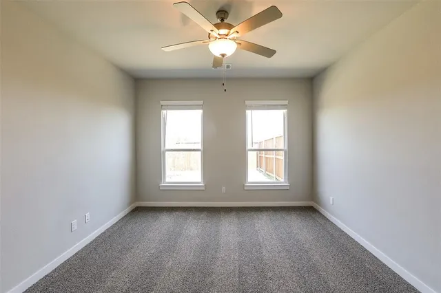 an empty room with a window and a fan