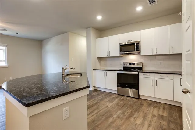 a kitchen with kitchen island a counter top space appliances and cabinets