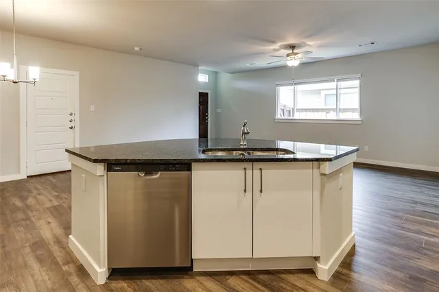 a kitchen with granite countertop cabinets and wooden floor