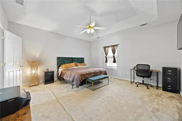 a spacious bedroom with a bed a desk and chair