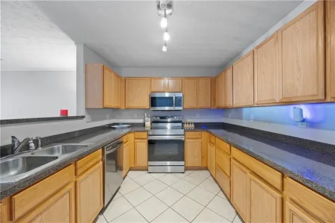 a kitchen with granite countertop a sink stainless steel appliances and cabinets