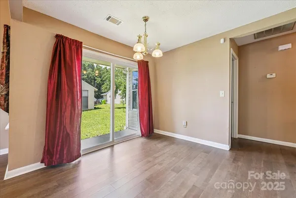 a view of a room with window ceiling fan and wooden floor