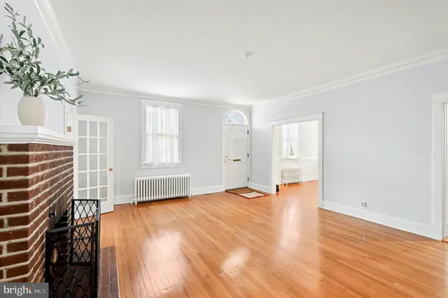 a living room with a fireplace and wooden floor