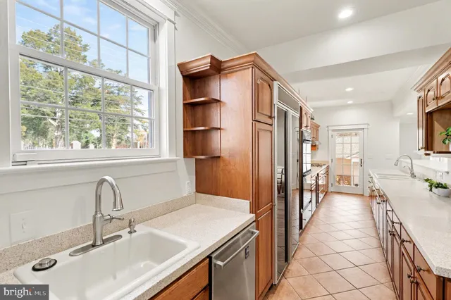 a kitchen with stainless steel appliances granite countertop a refrigerator and a stove top oven