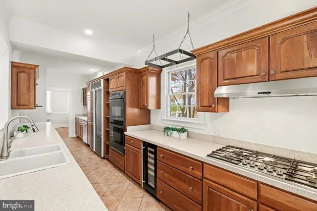 a spacious bathroom with stainless steel appliances a sink dishwasher a refrigerator and cabinets